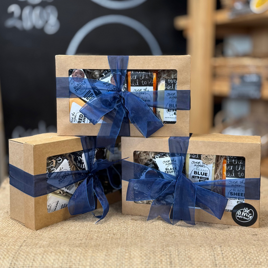 Three gift boxes with blue ribbons on a table with a store background